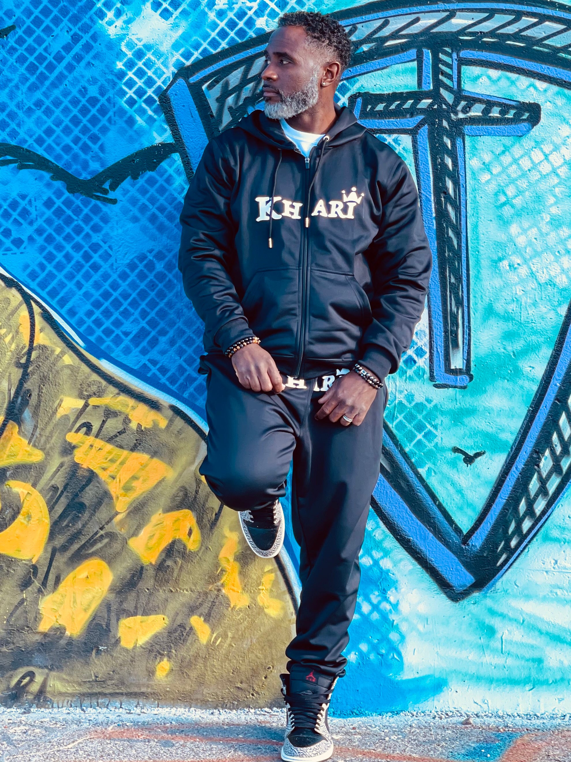 Modal in Khari Brand track suite with Khari logo across the front chest on the jacket
